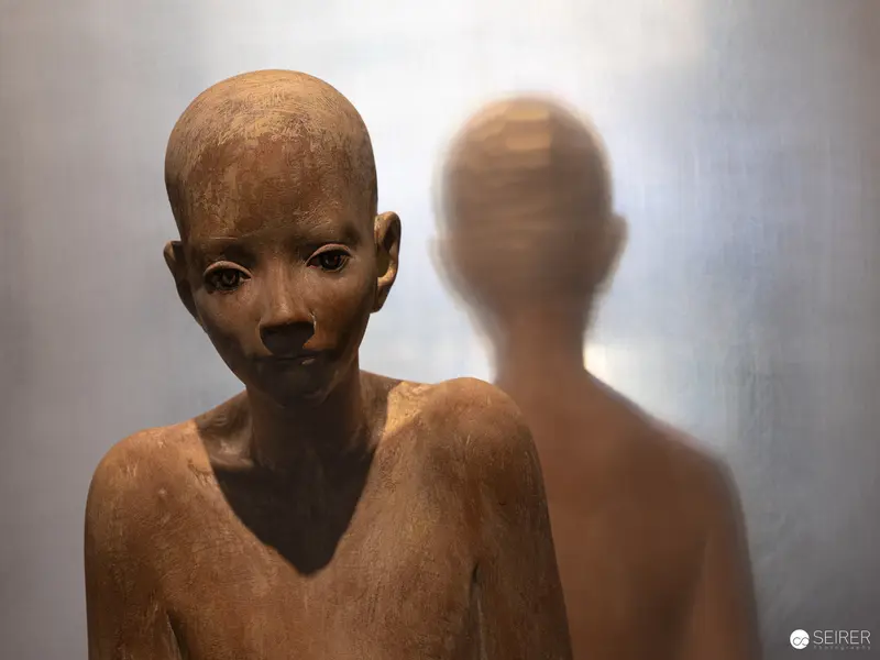 Textured Ceramic Sculpture of Pensive Figure with Shadowy Reflection