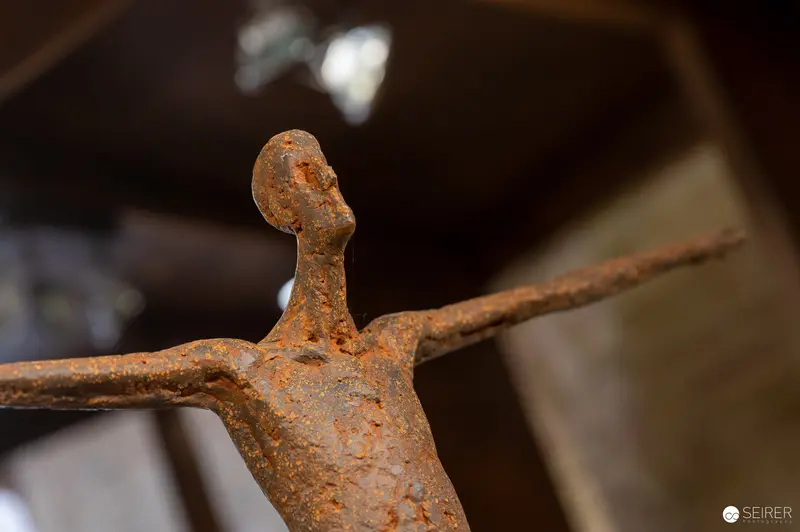 Rusted Sculptural Figure with Outstretched Arms in Abstracted Form