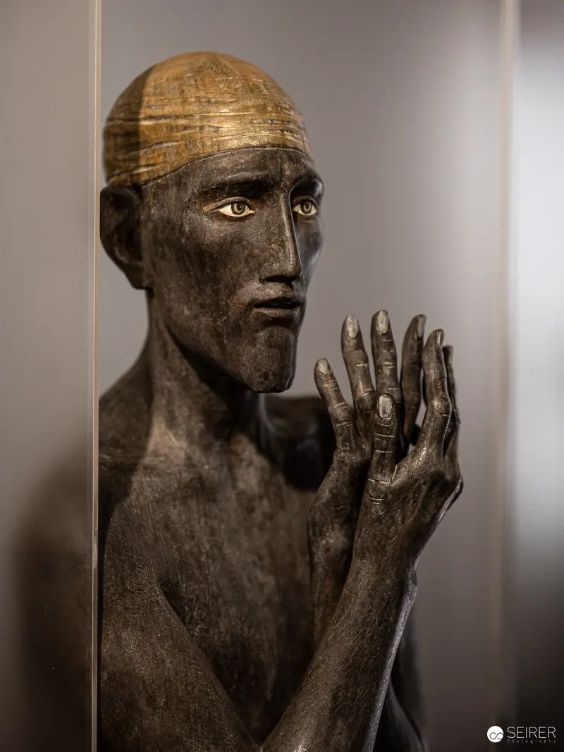 Bronze Sculpture of Contemplative Figure with Raised Hand at Isculpture Gallery