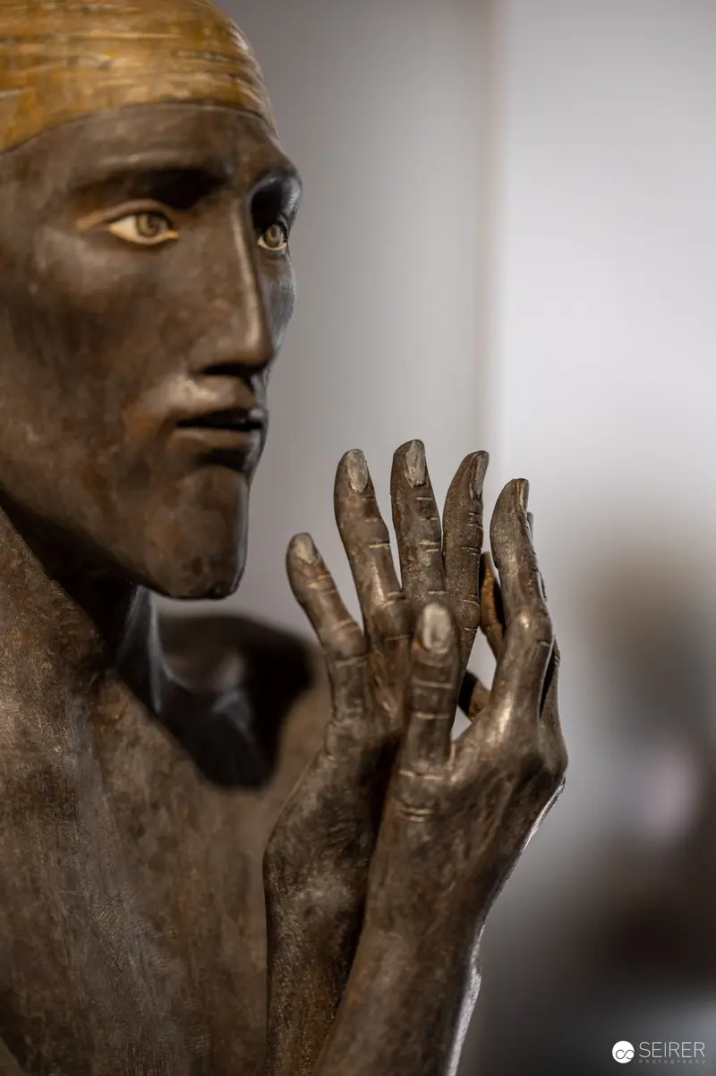Bronze Sculpture of Contemplative Figure with Raised Hand at Isculpture Gallery
