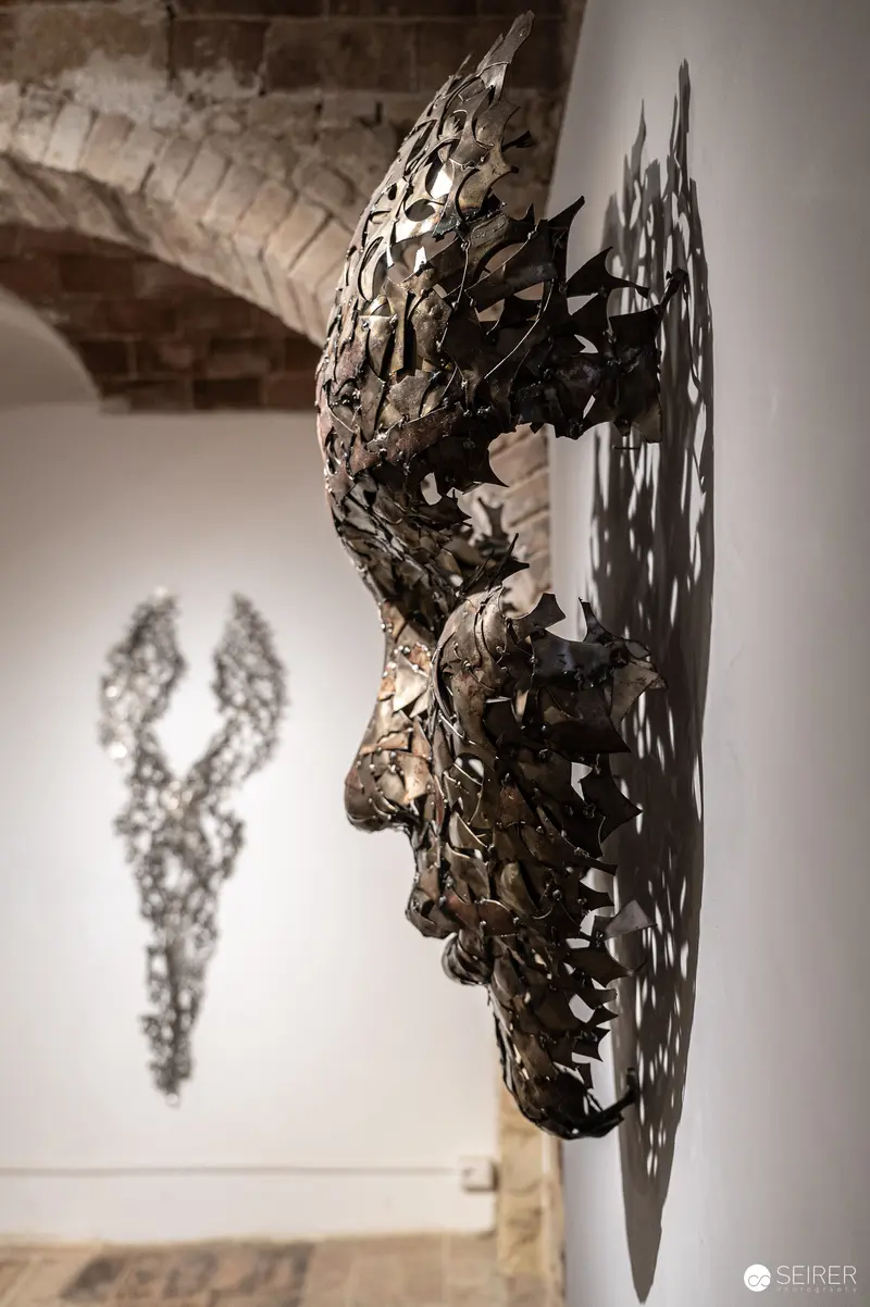 Intricate Metal Sculpture Casting Shadowy Silhouette at Isculpture Gallery San Gimignano