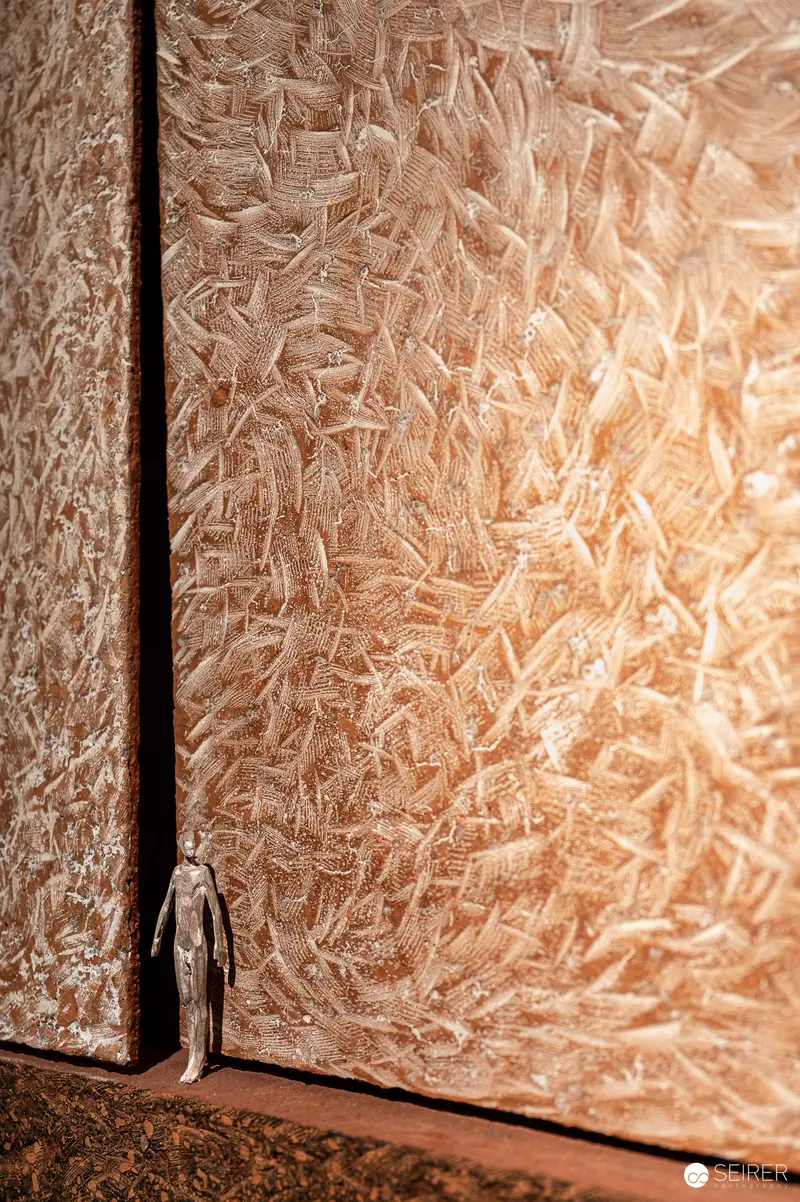 Miniature Figure Dwarfed by Textured Organic Wall Surface in Dramatic Perspective