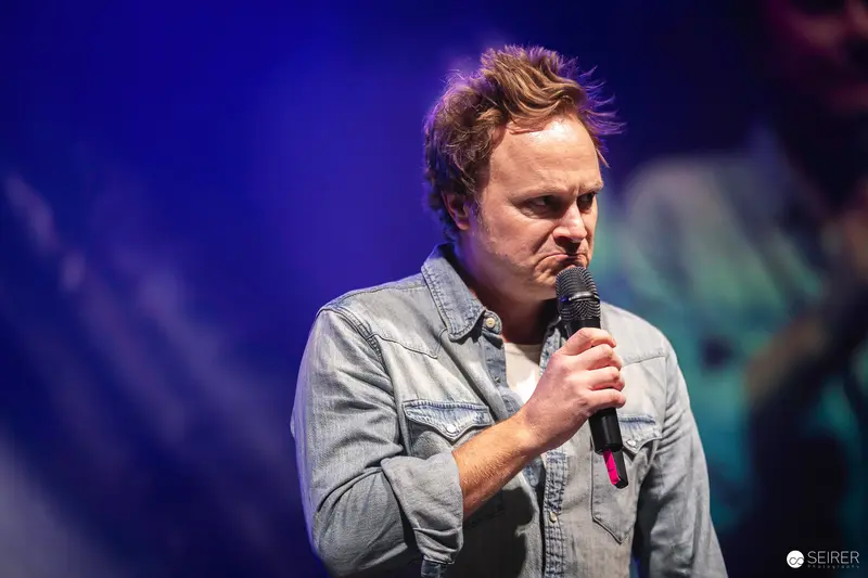 Comedian Performing on Stage with Microphone at Vienna ComicCon 2023