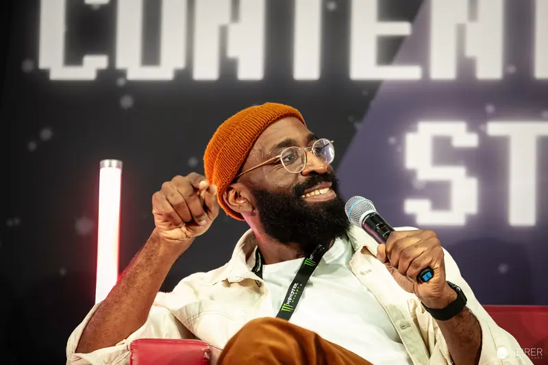 Bearded Speaker in Orange Beanie at Vienna ComicCon 2023 Panel Discussion