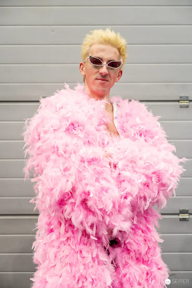 Eccentric Performer in Vibrant Pink Feathered Outfit at Comic Convention