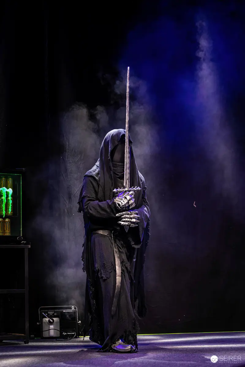 Hooded Figure with Sword in Dark Theatrical Staging at Vienna ComicCon 2023