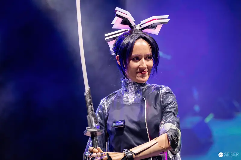 Cosplayer with Lightsaber at Vienna ComicCon 2023 in Stylized Costume