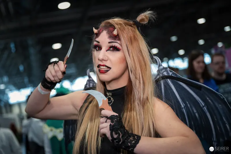 Demonic Cosplay Performer at Vienna ComicCon 2023 with Theatrical Makeup and Prop Knife
