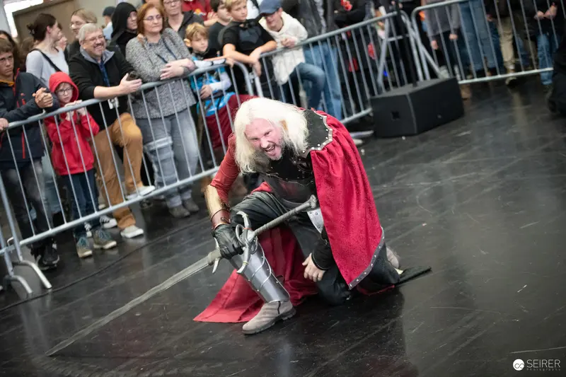 Costumed Performer in Red Cape Dramatically Poses at Vienna ComicCon 2023