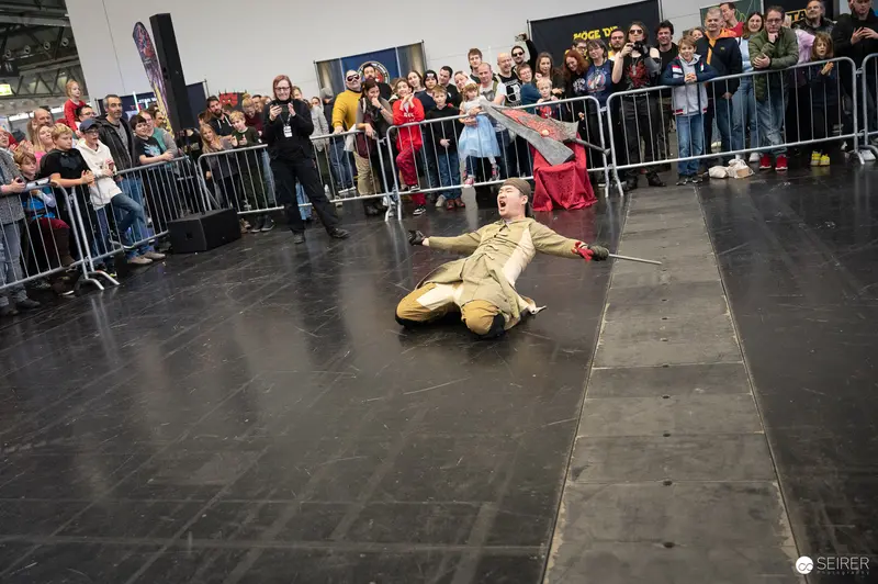 Performer Lies Dramatically on Stage During Bis Einer Weint at Vienna ComicCon 2023