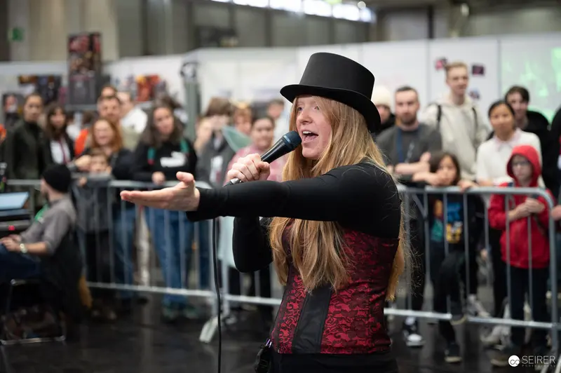 Bis Einer Weint Performer Singing at Vienna ComicCon 2023 with Passionate Gesture