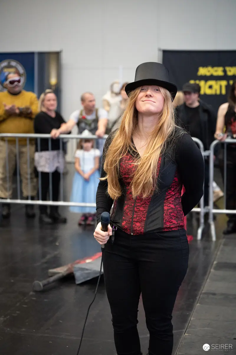 Bis Einer Weint Performance at Vienna ComicCon 2023 in Black Hat and Costume