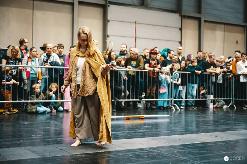 Cosplayer in Golden Cape Performing at Vienna ComicCon 2023 Lightsaber Battleshow