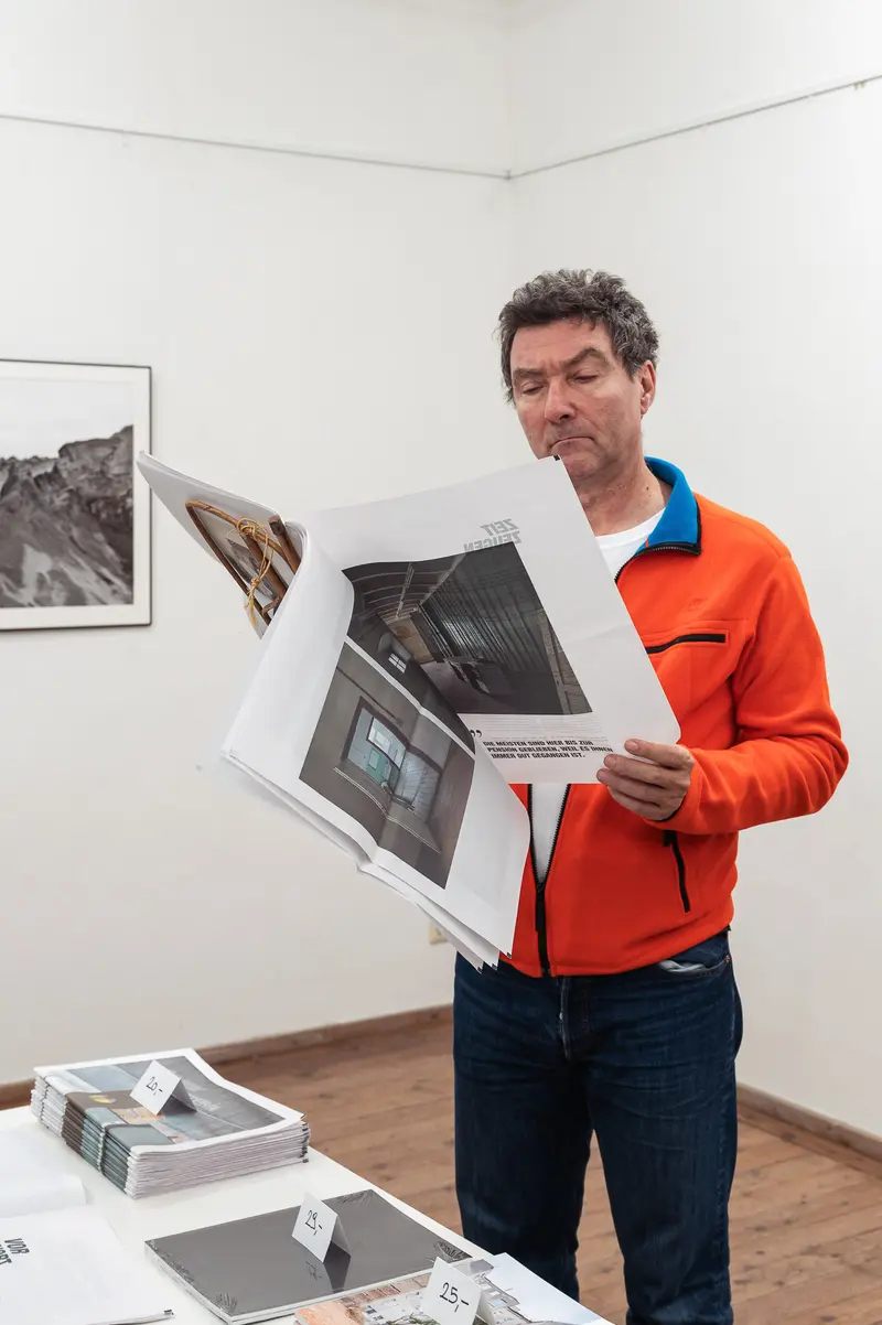 Thomas Schlader Examining Architectural Photographs at Diploma Exhibition