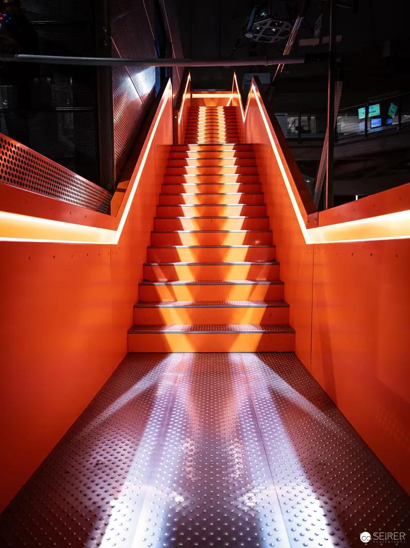 Illuminated Orange Staircase with Dramatic Lighting in Modern Interior