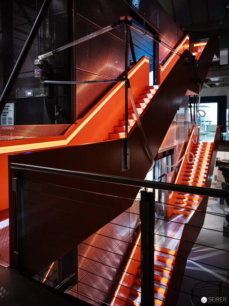 Modern Architectural Staircase with Dramatic Orange Illumination at Museum