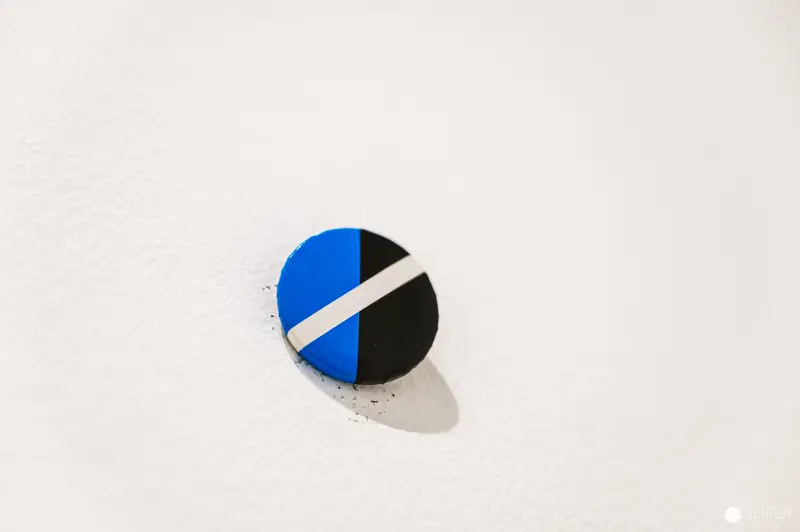 Blue and Black Circular Graphic Design Element with White Stripe