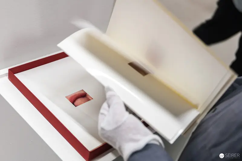 White-Gloved Hands Opening Archival Book at MUSA Exhibition 2024