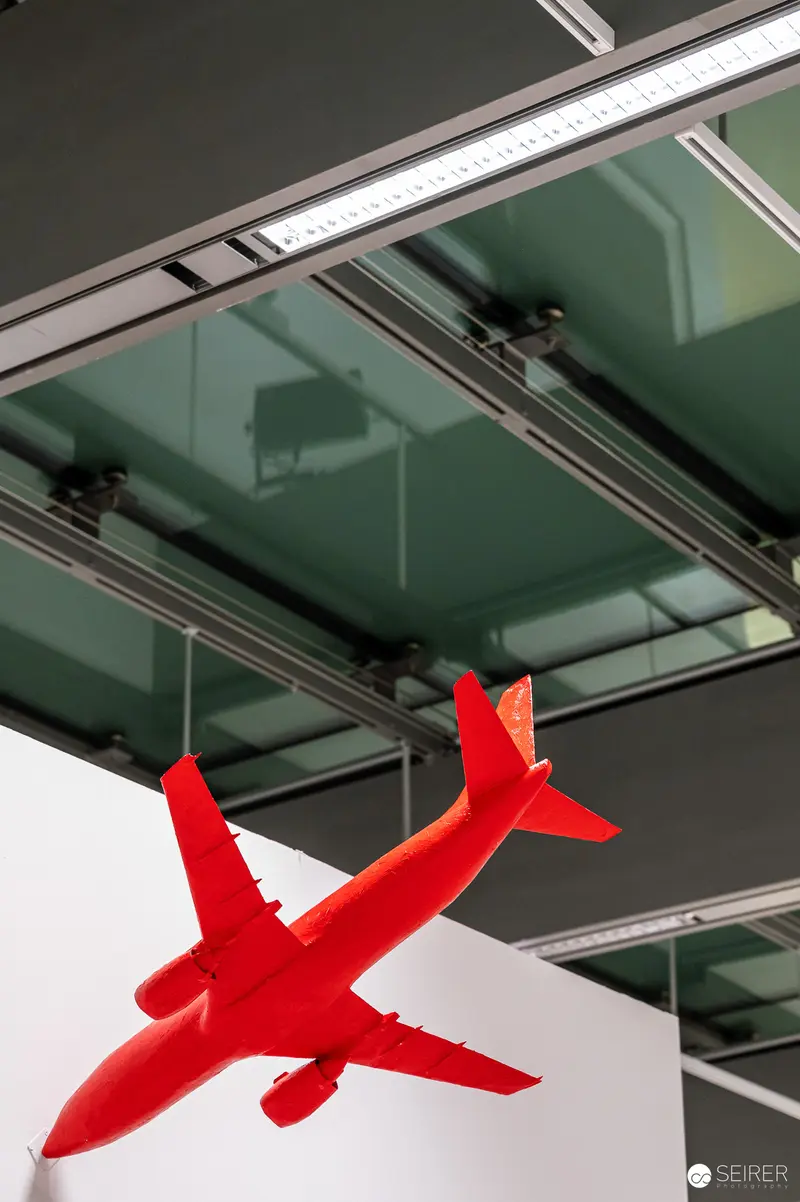 Red Aircraft Model Suspended in Modern Gallery Space