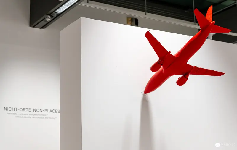 Red Airplane Model Suspended at MUSA Exhibition "2000er - Bye-Bye Zuversicht"