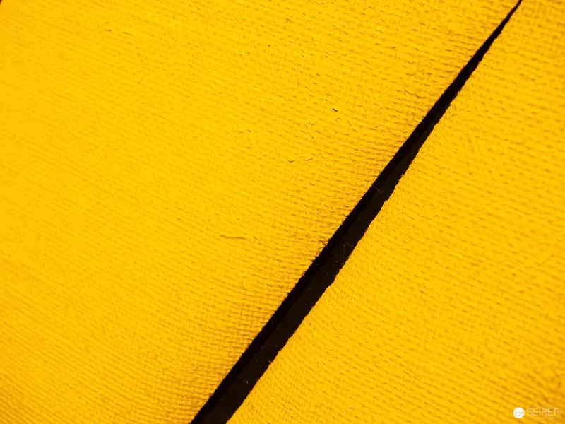 Vibrant Yellow Surface with Diagonal Black Tear or Slice
