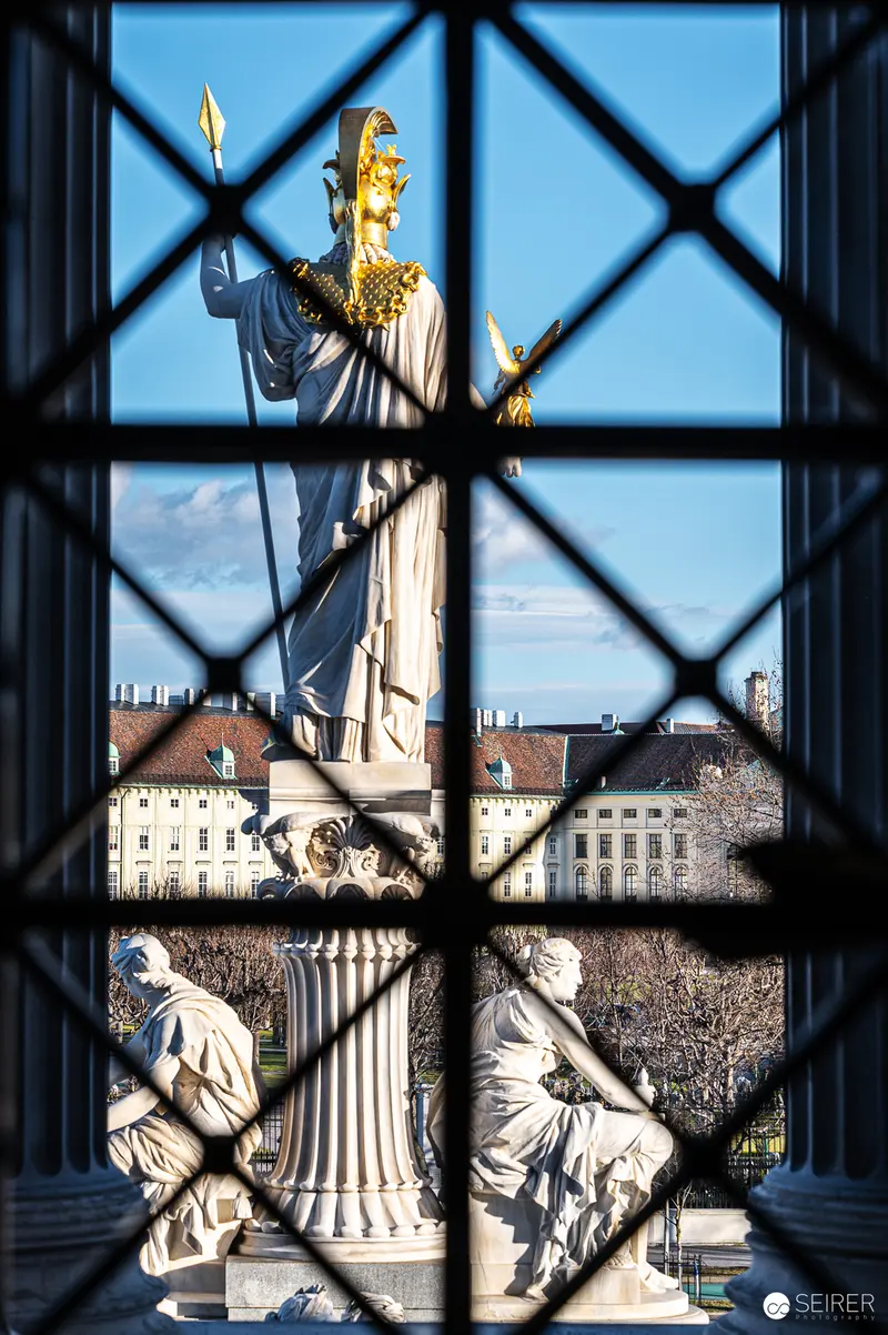 Golden Statue of Justice Framed by Window at Austrian Parliament Building
