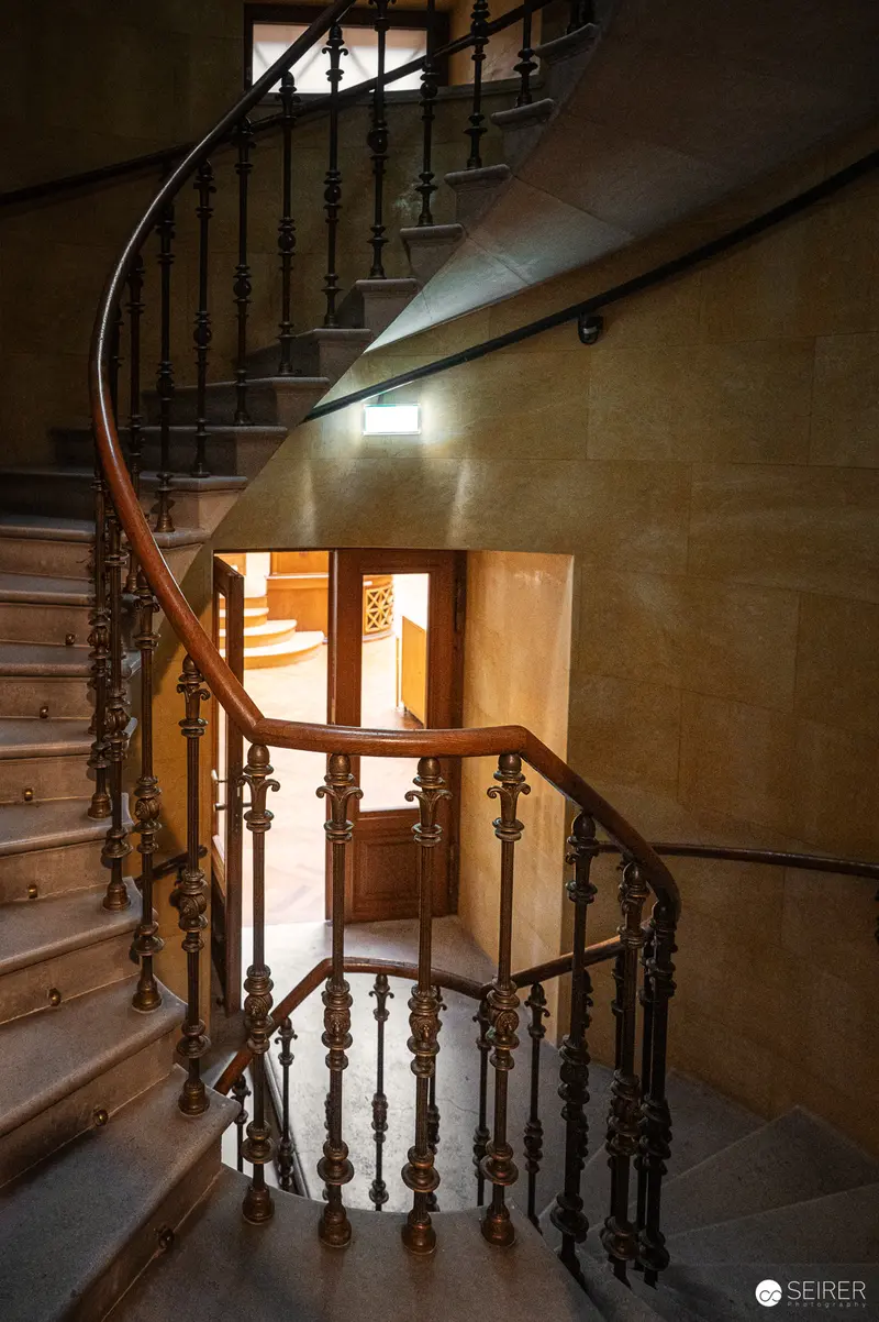 Curved Wooden Staircase with Ornate Railings in Historic Interior