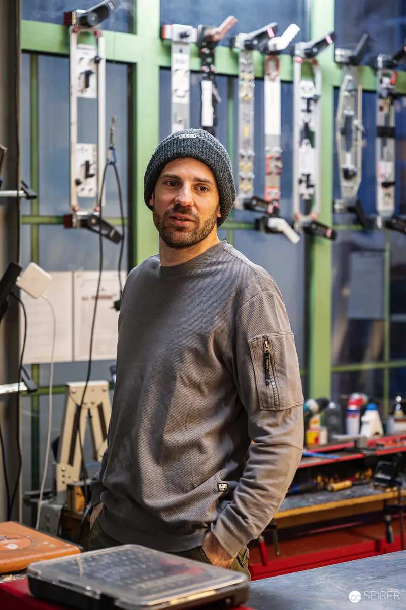 Craftsman at Ünique Skis Workshop in Vienna, Wearing Knit Hat and Gray Sweater
