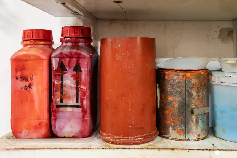 Weathered Red Chemical Containers on Industrial Workshop Shelf
