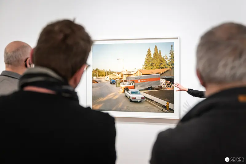 Visitors Examining Joel Sternfeld's "American Prospects" Roadside Photograph at Albertina