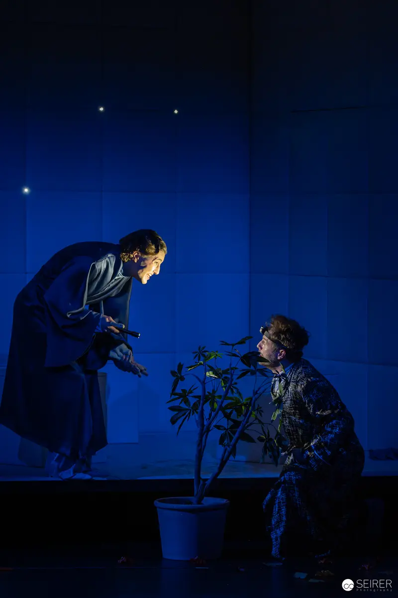James Brown and Theatrical Plant Scene in Blue-Lit Dramatic Performance