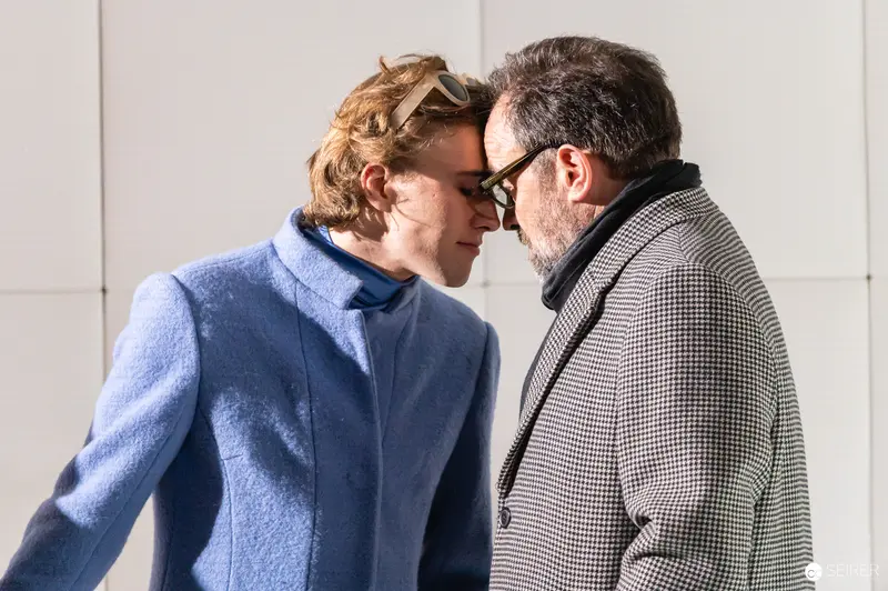 Intimate Moment Between Two Actors in Blue Coat and Checkered Jacket