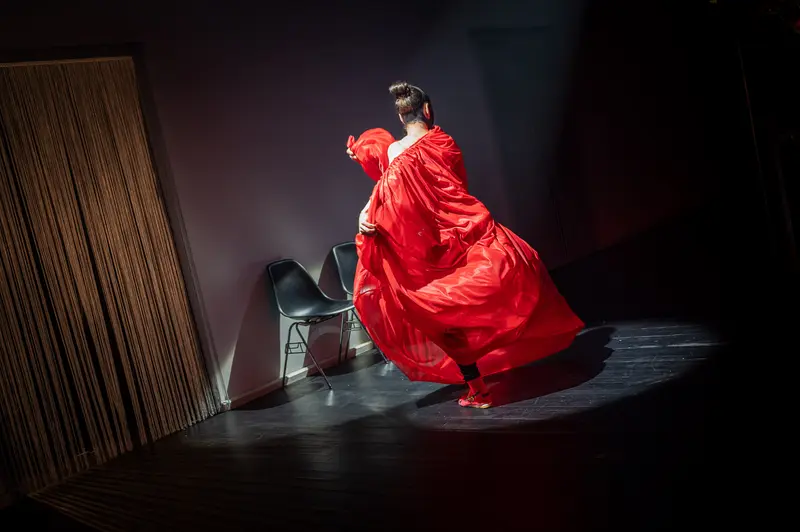 Red-Cloaked Performer in Dramatic Staging at Kosmos Theater, Wien