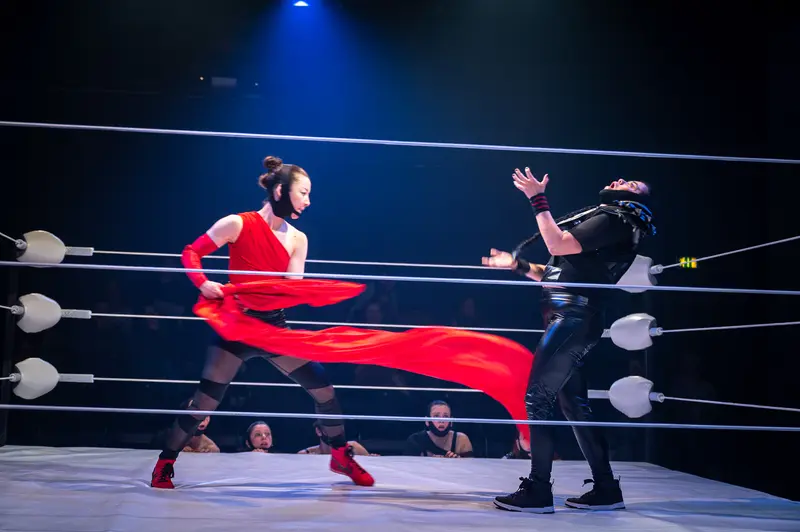 Dynamic Wrestling Performance at Kosmos Theater, Wien Featuring Dramatic Red Costume