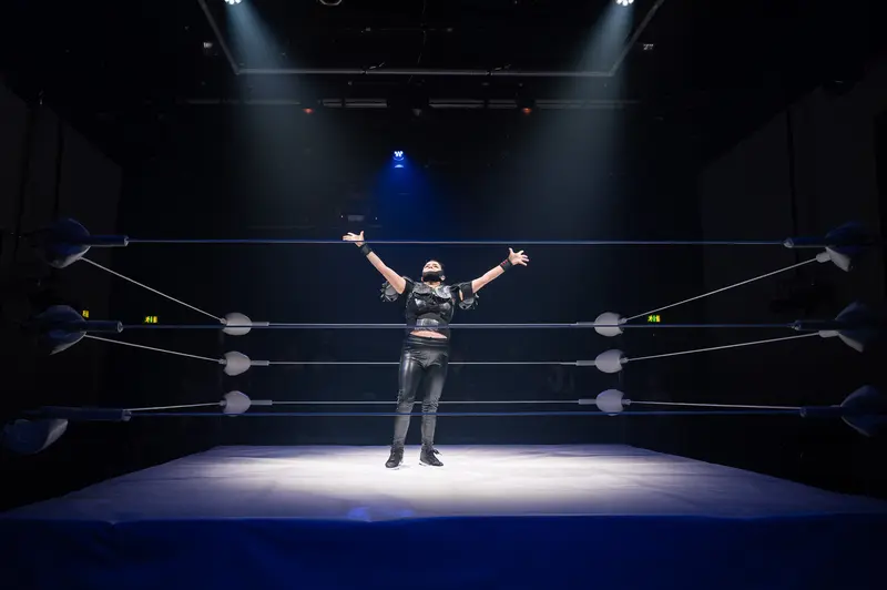 Wrestler Dramatic Pose in Spotlit Wrestling Ring at Kosmos Theater