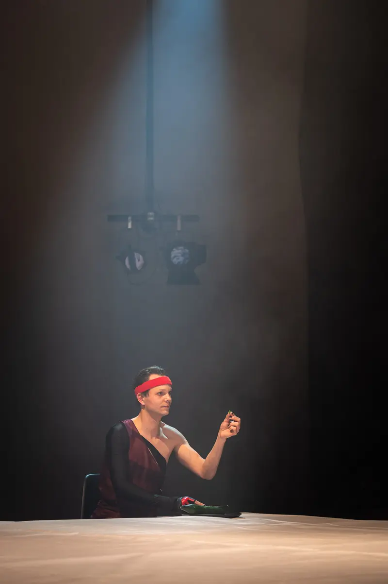 Seated Performer in Red Headband at Kosmos Theater's "Keeping up with the Penthesileas"