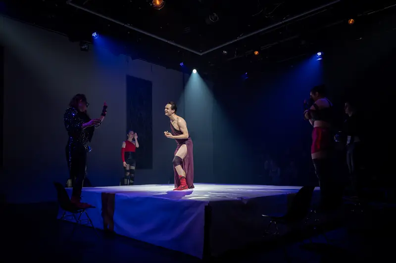Penthesileas Performance at Kosmos Theater: Dramatic Staged Moment in Blue Light