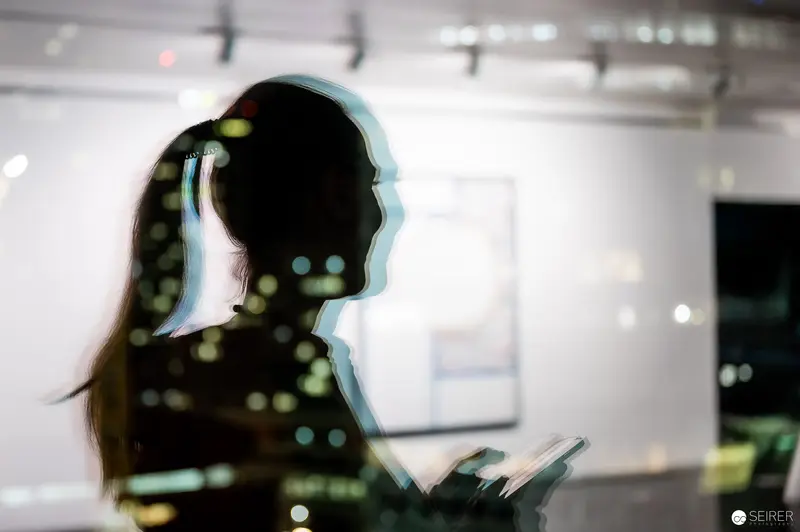 Silhouetted Visitor Exploring "Storyteller" Exhibition by Grzegorz Siembida