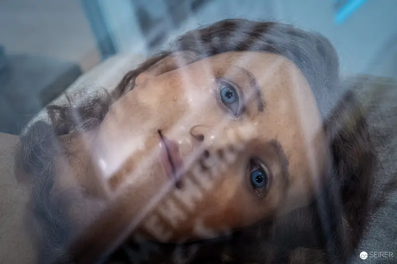Introspective Portrait with Layered Reflections and Soft Blue Gaze