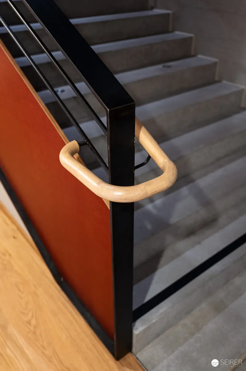 Sleek Modern Staircase with Curved Wooden Handrail in Urban Interior