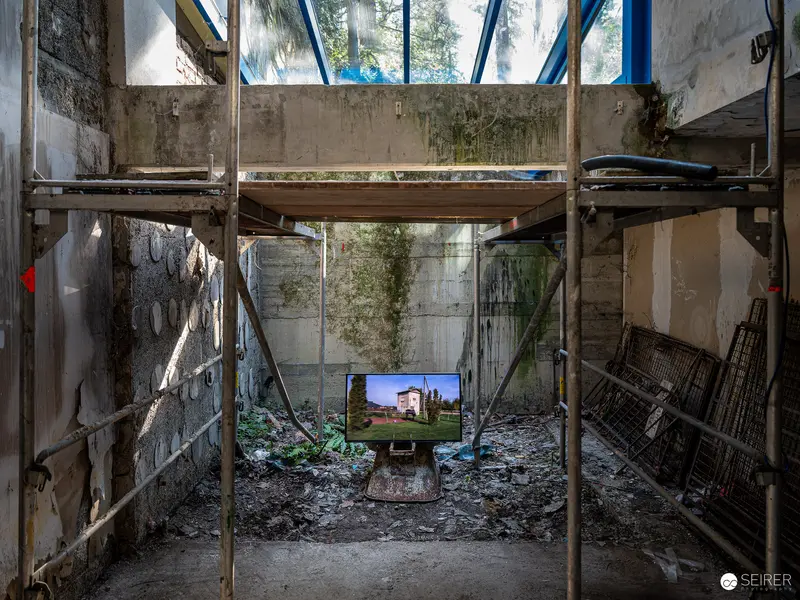 Abandoned Interior with Vintage Television Screen Displaying Architectural Image