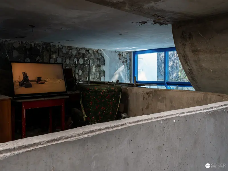 Nocturnal Cave Exhibition: Concrete Interior with Blue Window and Artwork