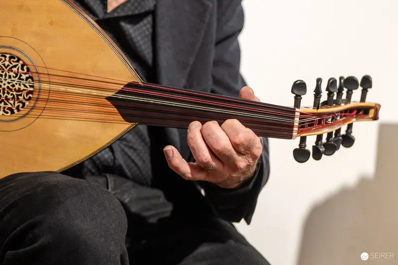 Traditional Middle Eastern Oud Instrument Held by Musician in Performance Pose