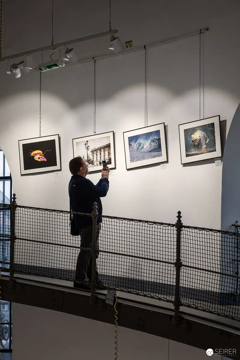 Curator Hanging Photographs at "Water Source of Life" Exhibition in Favoriten Water Tower
