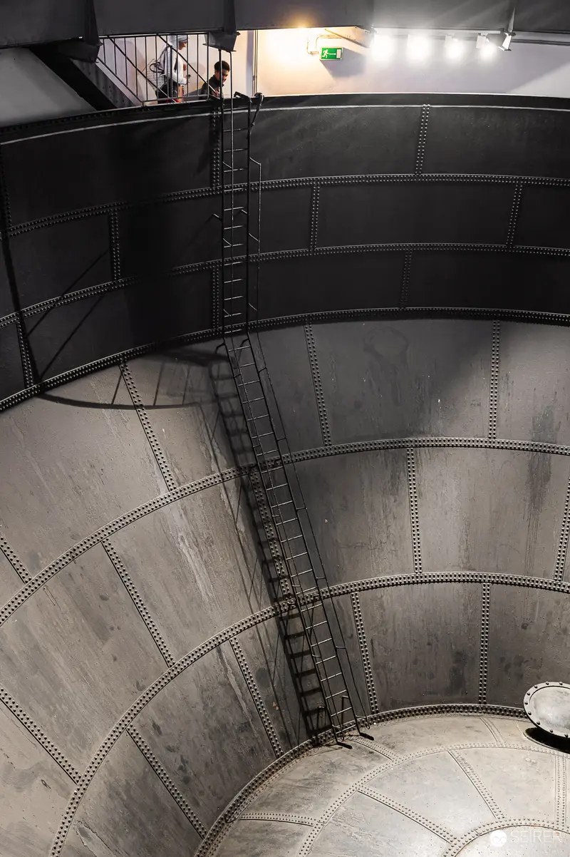 Industrial Water Tower Interior with Spiral Staircase and Metal Walls