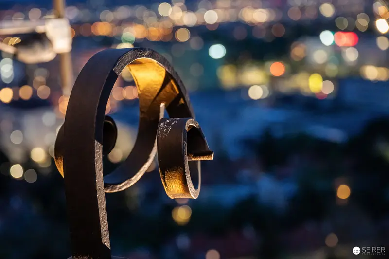 Metallic Rings Sculpture Illuminated Against Blurred City Lights at Night
