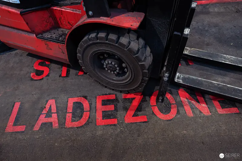 Red Loading Zone Marking with Forklift Wheel at Industrial Site