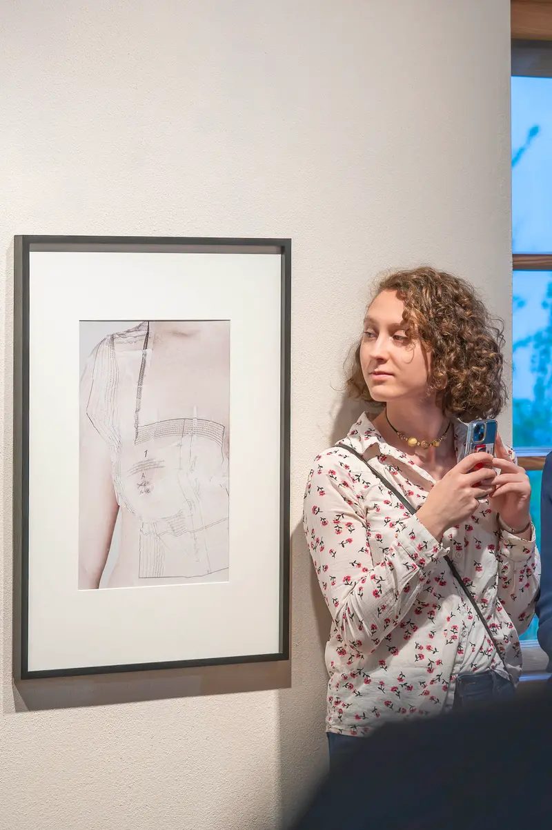 Gallery Visitor Examining Framed Monochromatic Artwork at "Hide & Seek" Exhibition in Traismauer
