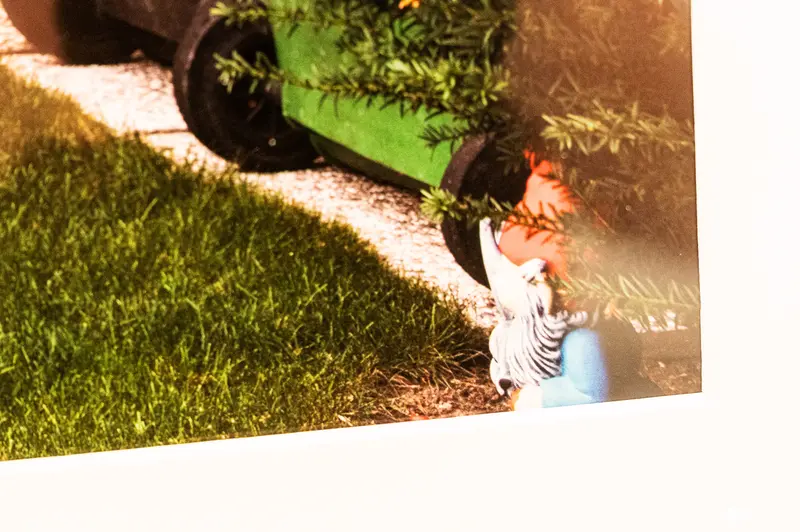 Child in Zebra-Striped Shirt Playing Near Green Car on Grass Path