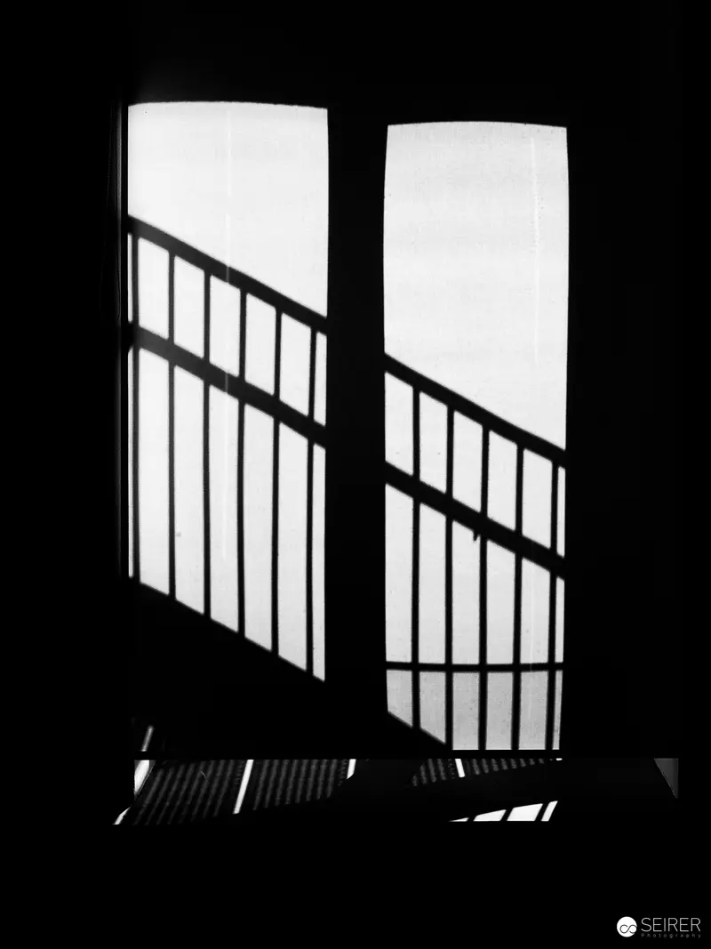 Stark Black and White Window with Geometric Railing Shadow
